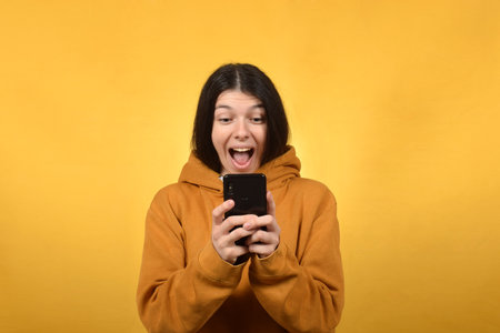 happy young brunette woman doing online shopping on smartphoneの写真素材