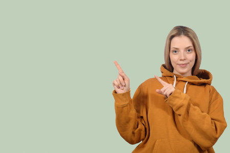 cute blonde woman pointing direction with fingerの写真素材