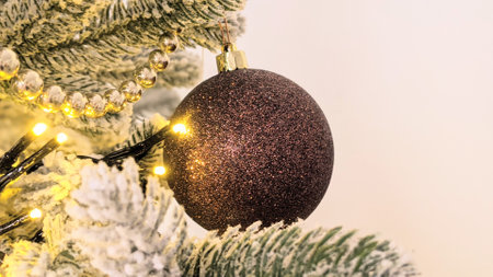 Christmas tree decoration with bokeh lights and red bauble.