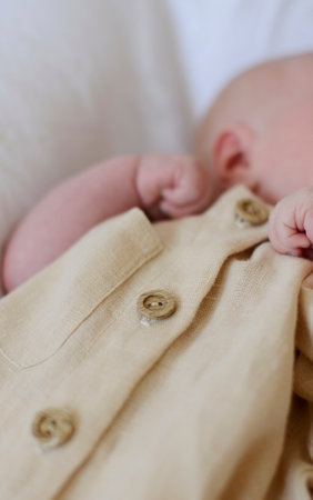 Newborn baby in a beige jacket close-up. Newborn babyの写真素材