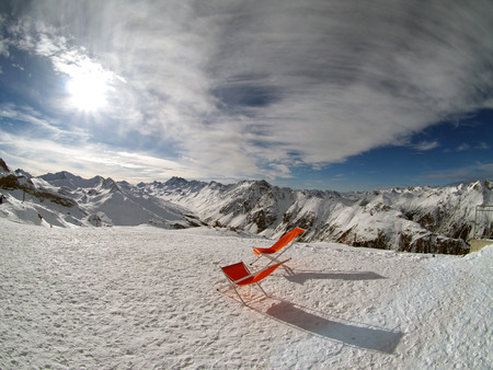 two red beach chairs on the background of the Alpsの写真素材