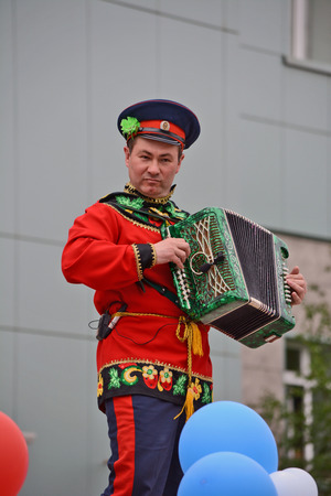 Mirny, Russia - June 12, 2014: Accordion player in national Russian clothes in celebration of the Day of Russia in the city of Mirny, Republic of Sakhaのeditorial素材