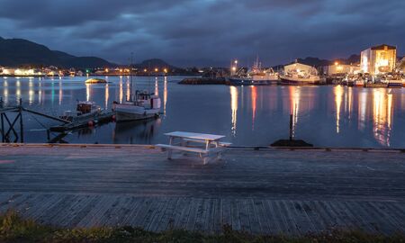 Evening lights in the fishing village on the Lofoten islands, Norway with view to mountainsの写真素材