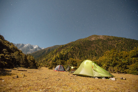 Tents and bicycles at night  with moon light in the Himalayas,  Tibet region of China at autumn timeの写真素材