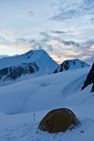 Beautifull view to snow mountains and tent on the glacier in Altaj, Russia  at the summerの写真素材