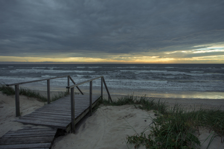 Dark sunset on the sea with waves from sand beach on the Curonian spit at the summerの写真素材