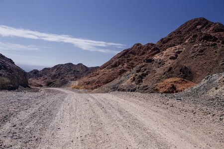 Way in the desert  in the Israil in sunny day with red mountains and blue sky near Eilatの写真素材