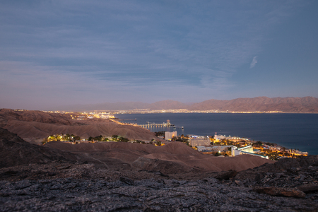Veiw from mountains to israil and iordan mountains near  of Eilat city in the desert  in the evening sunset  with blue sky and city lightsの写真素材