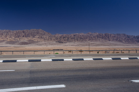 Road in the desert  in the Israil in sunny day with view to red iordan mountains and blue sky near Eilatの写真素材