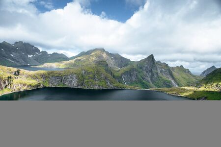 View from mountain to sea and  black lakes on the Lofoten island at summer in the north of Norwayの写真素材