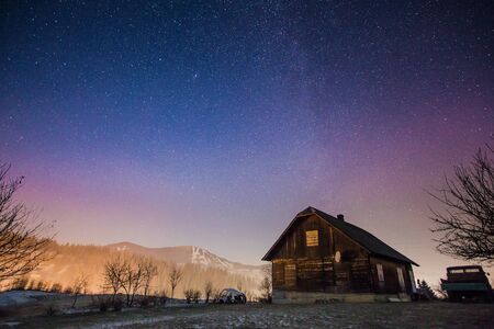 Abandoned house at night with stars and milky way in the Carpatian mountainsの写真素材
