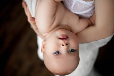 Mother holds baby. Baby is looking from bottom to top.の写真素材