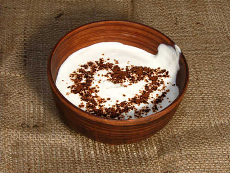 Romantic breakfast with painted heart on Valentine's Day on jute background. Sour cream served in handmade old pottery. Heart is drawn from chocolate.                                の写真素材
