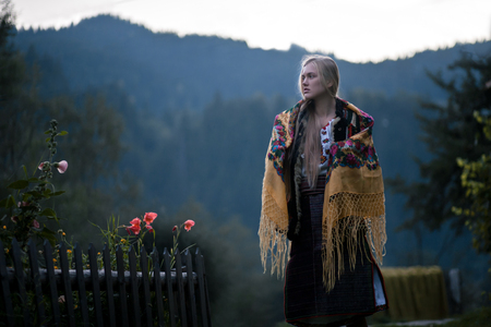 Ukrainian hutsul woman in national costume with shawl on her shoulders. Against mountains background.の写真素材