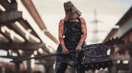 Mutant monster with weapon in form of hammer, saw and an ax. Imagination. Mutant with sack on his head.の写真素材