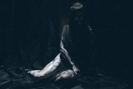 A young woman in the image of a humanoid and extraterrestrial alien with horns on her head and a pattern on the body like a reptile.の写真素材