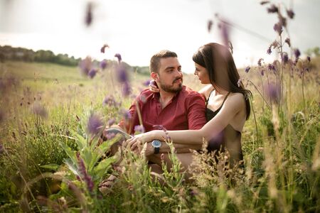 A young couple is resting in a meadow among the flowers.の写真素材