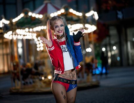 Dnipro, Ukraine - August 17, 2016: Smiling girl in costume Harley Quinn on background of night city lights. Cosplayのeditorial素材