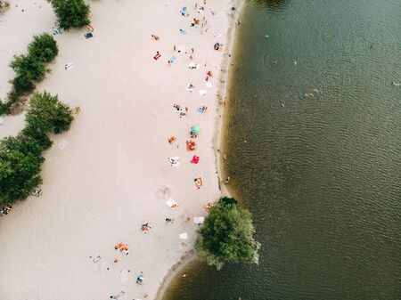 Beautiful view from the drone to the sand white beach, river and swimming and sunbathing people.の写真素材