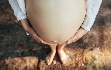 Belly standing pregnant woman closeup. Top view.の写真素材