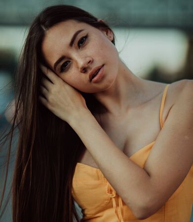 Portrait of a young woman with loose long hair in a yellow dress.の写真素材