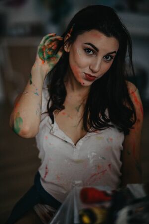 The portrait of artist stained with paint in an art workshop.の写真素材