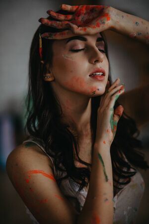 The portrait of artist stained with paint in an art workshop.の写真素材