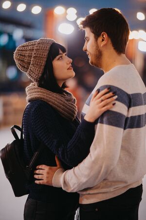 Young couple stands and embraces on the background of evening city lights.の写真素材