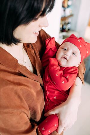 Mother holds the baby in her arms in the room.の写真素材