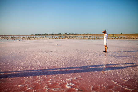 A photographer with a backpack and a digital camera in his hands admires the beautiful landscape on...