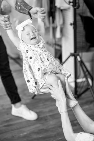 Parents have a fun and play with their little daughter. Black and white image.の写真素材