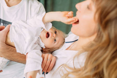 Happy young parents have fun and play with their little son.の写真素材