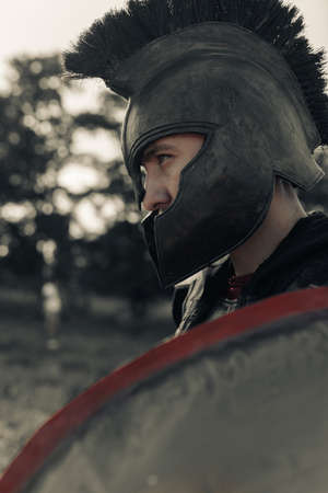 Portrait of ancient Spartan warrior in helmet with shield.の写真素材