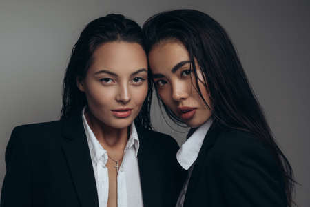 Portrait of two happy young women posing in studio with long hair.の写真素材