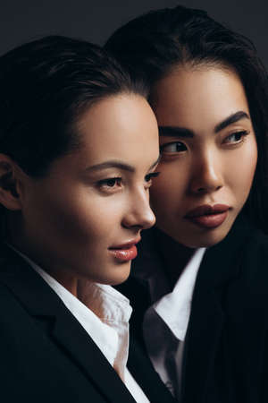 Portrait of two brunette young women posing in studio.の写真素材