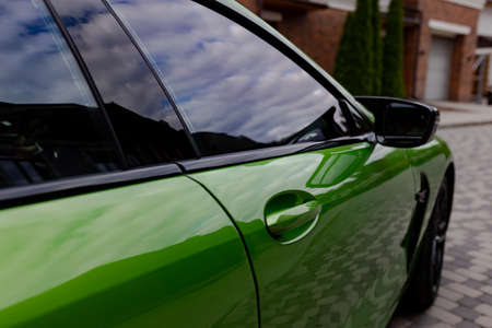 Side view to modern green car on parking near house. closeup.の写真素材