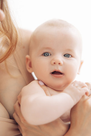 Young mother holds her happy baby on hands. portrait.