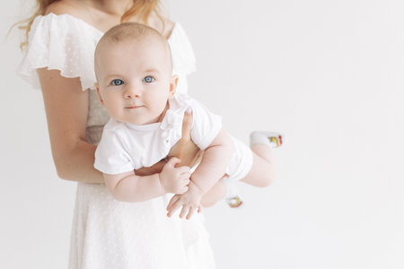 Mother plays with her baby against white background. closeup.の写真素材