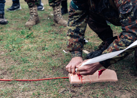 Soldier trains to stop bleeding from a gunshot wound using tamponade on a bullet wound simulator. Simulators for tactical medicine. Disaster medicine and military medicine. stop bleeding.の写真素材