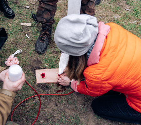 Woman trains to stop bleeding from a gunshot wound using tamponade on a bullet wound simulator. Simulators for tactical medicine. Disaster medicine and military medicine. stop bleeding.の写真素材