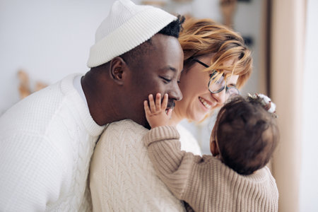 Happy interracial family has fun and plays with their baby daughter. Concept of interracial family...