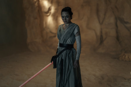 Kyiv, Ukraine - April 14, 2023: Cosplayer girl portrayings character Rey Skywalker from the Star Wars universe and the protagonist of the sequel film trilogy with lightsaber among sandy canyon.のeditorial素材
