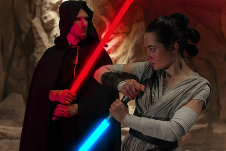 Kyiv, Ukraine - April 14, 2023: Cosplayers portraying lightsaber combat between characters enemies Rey Skywalker and Kylo Ren from the Star Wars universe among sandy canyon.のeditorial素材