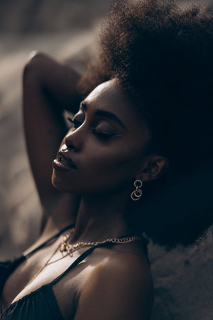 Portrait of pretty young African woman with closed eyes posing against background of canyon.の写真素材