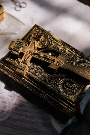 Close-up of a golden Orthodox cross on ornate Gospel book, placed on the altar during a church service. The intricate details, warm light and sacred atmosphere of the Orthodox Christian tradition.の写真素材