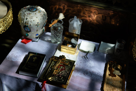 Close-up of a golden Orthodox cross on ornate Gospel book, placed on the altar during a church...