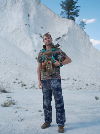 Ukrainian defender in a tactical vest stands in a chalk quarry. Portrait of soldier fighting for...