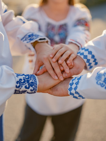 Close up Ukrainian family hands together in embroidery shirts showing unity, love, and support. Symbolic image of Ukrainian people standing strong together.の写真素材