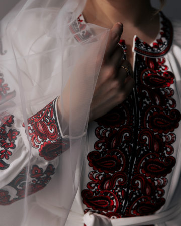 Ukrainian bride chest and hand, showcasing rich red and black Vyshyvanka embroidery, wedding ring,...
