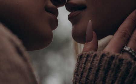 Extreme close-up macro shot young lesbian couple kissing and lips gently touching. Showing maximum intimacy, passion, sensuality, and deep emotional connection in diverse LGBT relationships.の写真素材